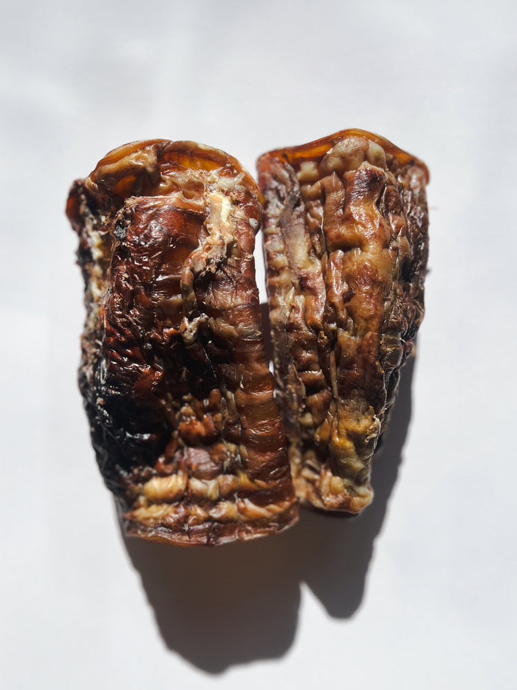 Two dried, shriveled figs on a white background